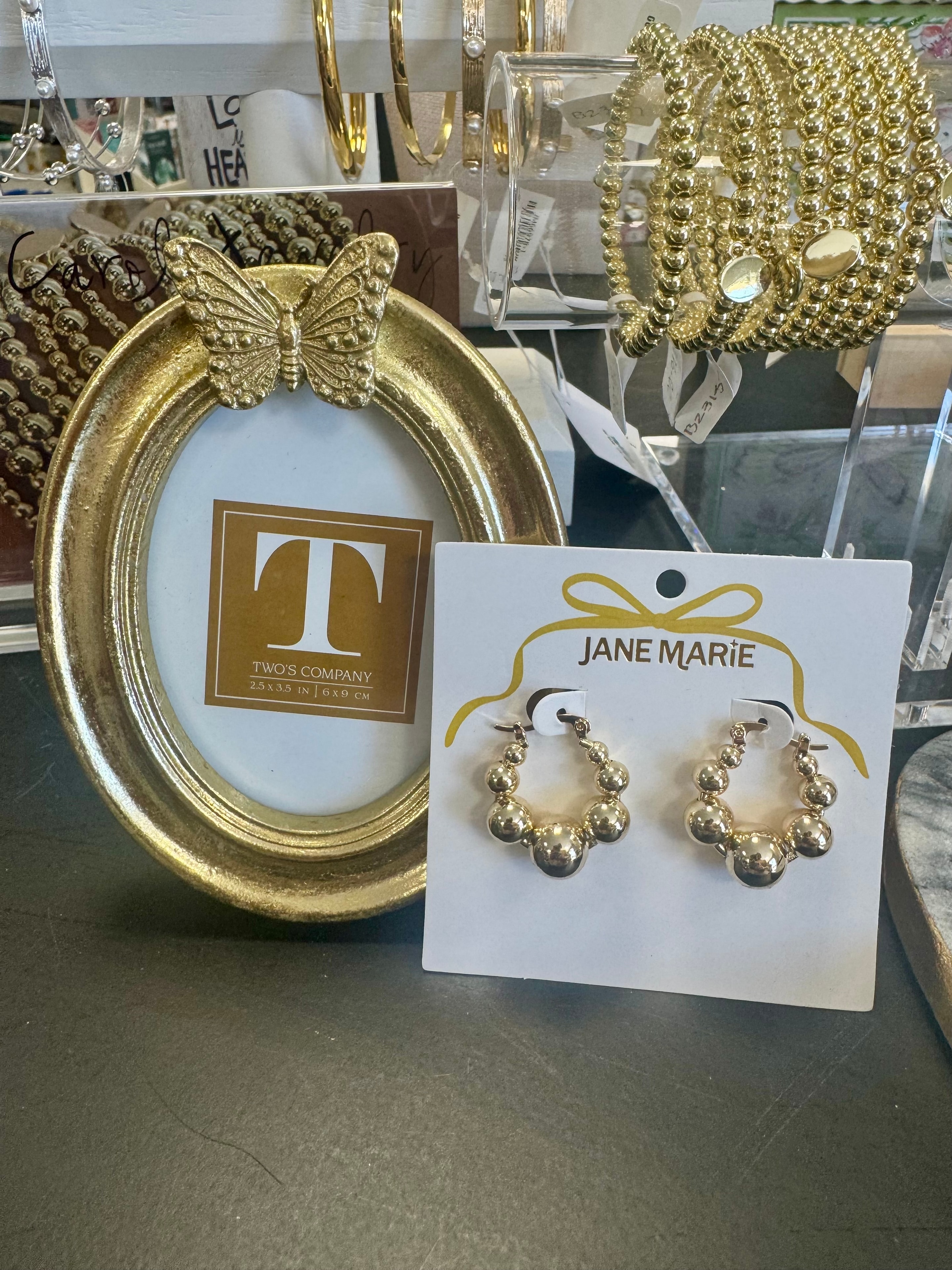 Gold hoop earrings and butterfly frame with bracelets